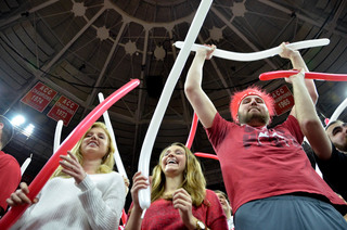 (From left) Kelsey Corkell, a junior textiles major, Holly Womack, a junior mechanical engineer and Alex Finis, a sophomore mechanical engineer, cheer on the Wolfpack from behind the hoop.