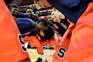 B.J. Johnson stands in the middle of the pregame huddle as Syracuse players smile around him.