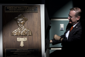 Chancellor Kent Syverud unveils a plaque of Sgt. William Shemin, an alumnus who was awarded the Medal of Honor in June.