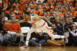 Michael Gbinije reaches his outstretched right arm to corral the ball before it escapes out of bounds.