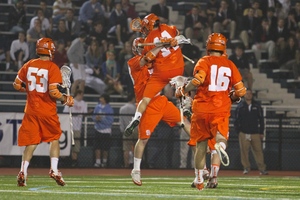 Tommy Palasek (center) leaps in the air in celebration during Syracuse's 15-6 win over Villanova on Thursday.