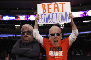 Fans put on masks of Jim Boeheim and John Thompson. 