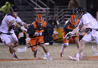 Orange midfielder Mike Messina goes for a ground ball in a crowd of Cavalier defenders. 