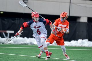 Long stick midfielder Austin Fusco works on St. John's Corey Haynes. 