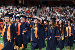 Heading to their seats, graduates wave to their families and friends. Anticipation built as the field filled with students.   